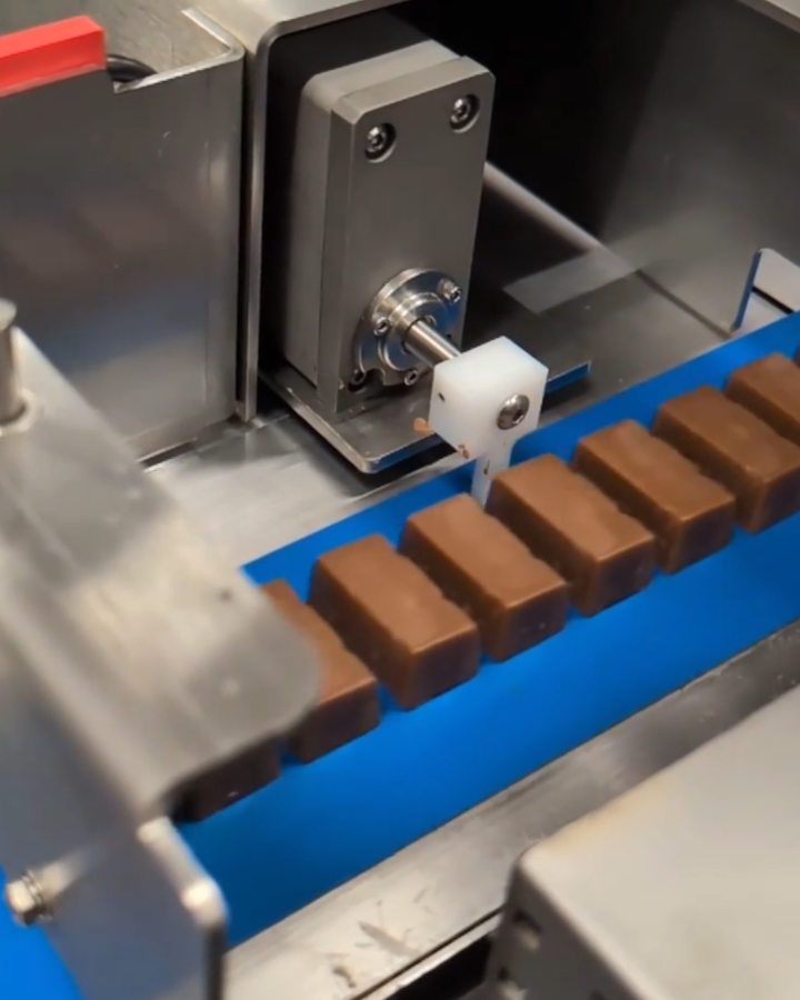 SMAC actuator pushing chocolate off a convayer belt